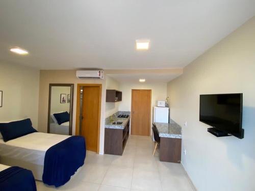 um quarto de hotel com uma cama e uma televisão de ecrã plano em Delú Residences em Alto Paraíso de Goiás