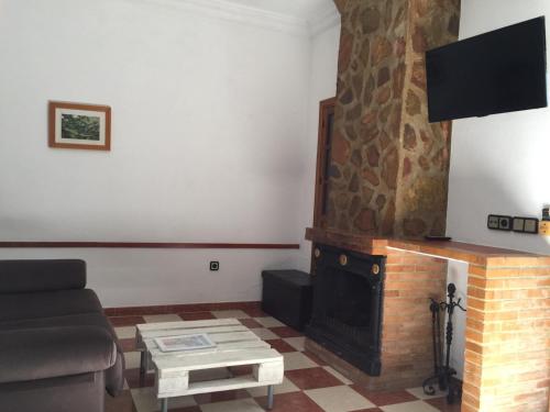 sala de estar con sofá y chimenea en El Mirador, en Benamahoma