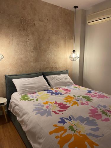 een slaapkamer met een bed met een kleurrijke deken bij Mel’s Place in Tirana