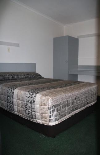 a bedroom with a large bed in a room at Bourbong St Motel in Bundaberg