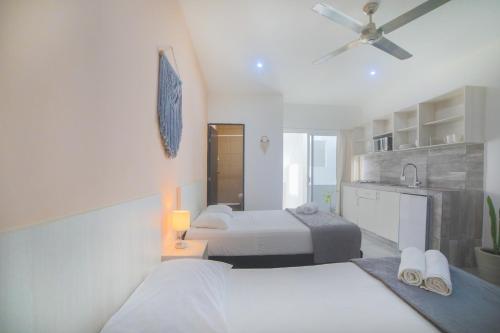 1 dormitorio con 2 camas y ventilador de techo en Almond Suites en Playa del Carmen