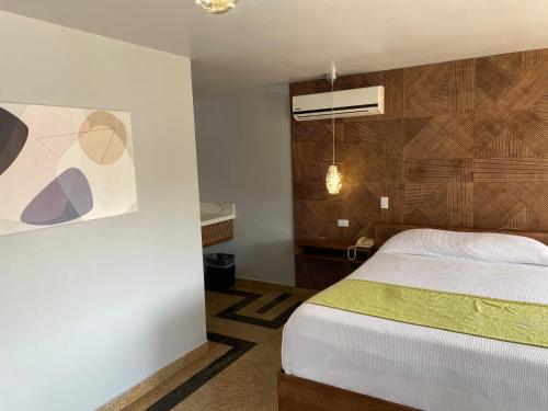a hotel room with a bed and a lamp at Hotel Aqua Rio in Tijuana