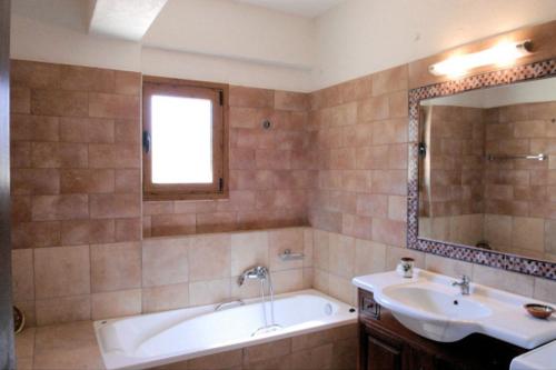 a bathroom with a tub and a sink and a bath tub at Crete Family Villas in Pentamodi