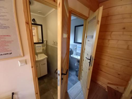małą łazienkę z toaletą i umywalką w obiekcie Domki Polanica w Polanicy Zdroju