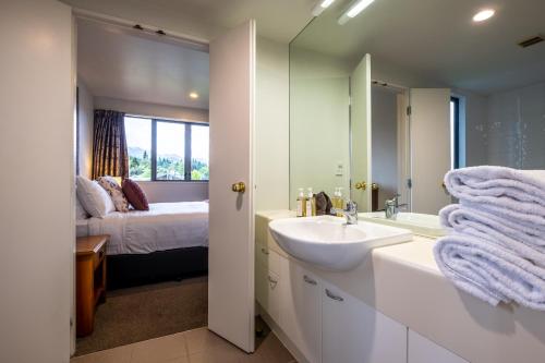 Un baño con lavabo, cama y espejo. en *** LAKE VILLA 461 ***, en Hanmer Springs