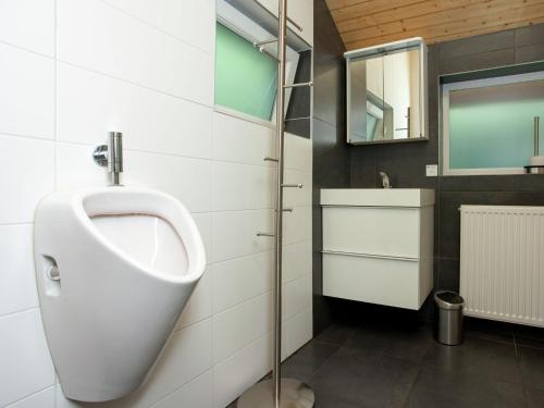 a bathroom with a urinal and a mirror on the wall at Modern Chalet in Sougné-Remouchamps near Forest in Aywaille