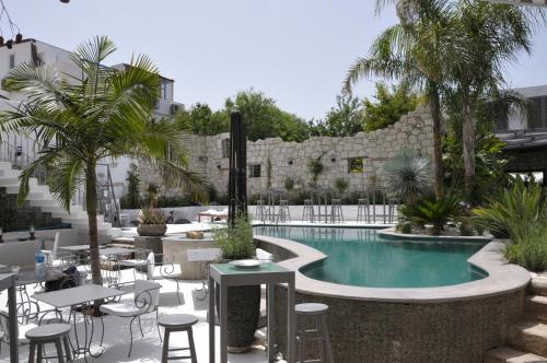 a courtyard with a pool and tables and chairs at Alaçatı Ala Hotel - Special Category in Alacati