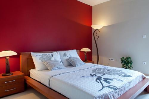 sypialnia z łóżkiem z czerwonymi ścianami i 2 lampami w obiekcie Apartments Toni w Omišu