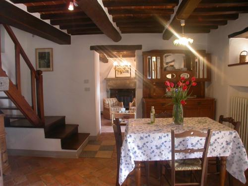 a dining room with a table with a vase of flowers on it at Ciliegio in Cortona