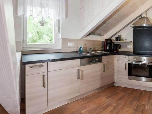 a kitchen with white cabinets and a sink and a window at Ruhige Ferienwohnung mit Parkplatz in Thale in Thale