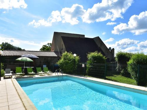 a pool with chairs and an umbrella next to a building at Gorgeous Villa in St Julien De Lampon with Private Pool Centre Nearby in Carlux