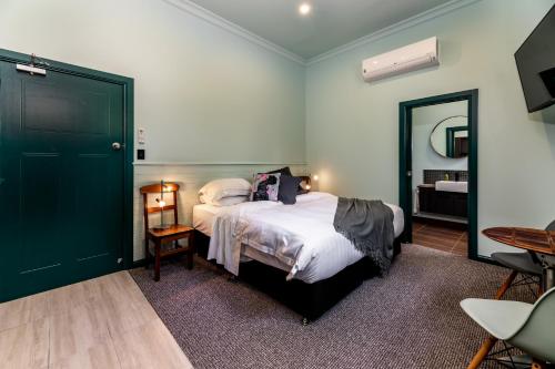 a bedroom with a large bed and a mirror at Tuck Inn Yarra Valley in Healesville