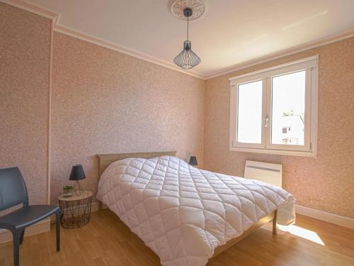 a bedroom with a large bed and a window at Comfortable apartment facing the museum in Arromanches-les-Bains