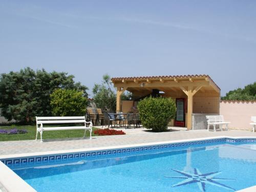 a swimming pool with a bench and a gazebo at Relaxing apartment in Banjole with shared pool and only 2 km from the sea in Banjole
