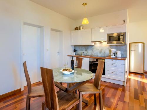 La cuisine est équipée d'une table, de chaises et d'un réfrigérateur. dans l'établissement Splendid Apartment in Murter with Swimming Pool, à Murter