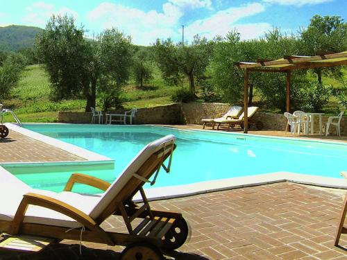 a swimming pool with a chair and a table at Farmhouse in Giano dell'Umbria in Giano dellʼUmbria