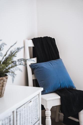 a white chair with a blue pillow on it at Barkers Run Terrace in Castlemaine