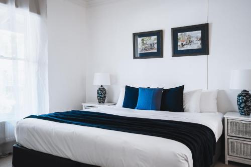 a bedroom with a large bed with blue and white pillows at Barkers Run Terrace in Castlemaine