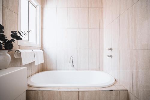 uma banheira branca na casa de banho com uma janela em Barkers Run Terrace em Castlemaine
