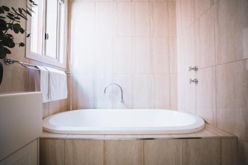 a white bath tub in a bathroom with a window at Johnstone Terrace in Castlemaine
