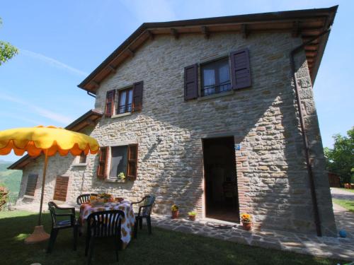 a stone house with a table in front of it at Belvilla by OYO Il Girasole in Apecchio