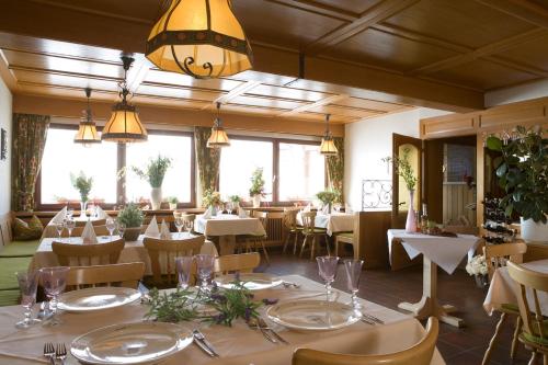 een restaurant met tafels en stoelen en een kroonluchter bij Landgasthaus Engel - Naturparkwirt in Höchenschwand