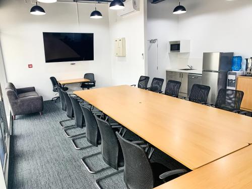 a conference room with a long table and chairs at Ramada Suites by Wyndham Albany in Auckland