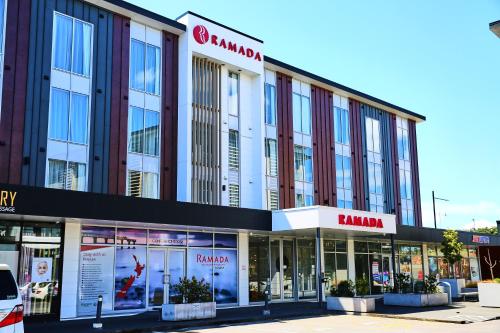 een winkel voor een gebouw met ramen bij Ramada Suites by Wyndham Albany in Auckland