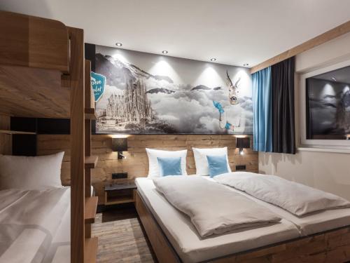 um quarto com 2 camas e um mural na parede em Graceful Chalet in Gaschurn with Sauna em Gaschurn