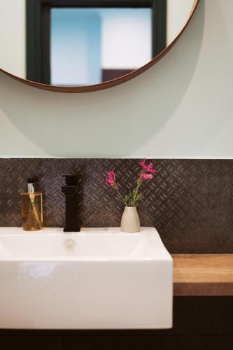 a bathroom with a white sink and a mirror at Tuck Inn Yarra Valley in Healesville