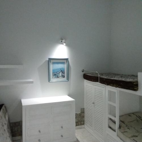 a bedroom with white cabinets and a picture on the wall at Perohouse in Cabo Frio