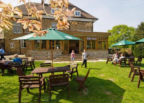 a group of people sitting at tables in front of a building at The Speech House in Coleford