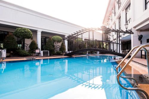 una piscina con un tobogán en un edificio en Marcian Garden Hotel, en Zamboanga