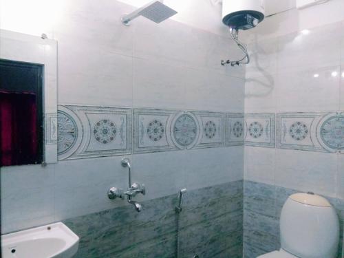 y baño con aseo, lavabo y espejo. en Amritchandra homestay and hostel, en Udaipur