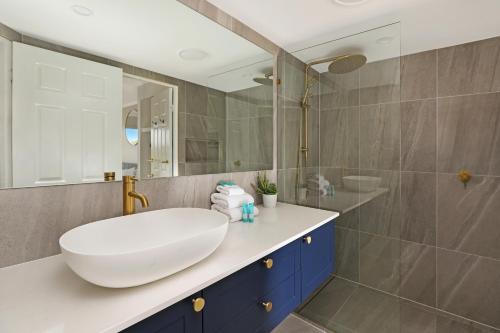 a bathroom with a white sink and a shower at Dockside Apartments Mooloolaba in Mooloolaba