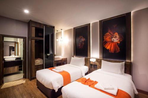 a hotel room with two beds and a mirror at The Cliff Elegance Resort in Ao Nang Beach