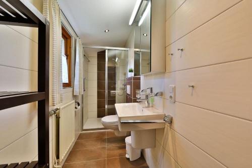 een badkamer met een wastafel, een toilet en een spiegel bij Waldsee-Ferienhaus-mit-Kamin-W-Lan in Clausthal-Zellerfeld