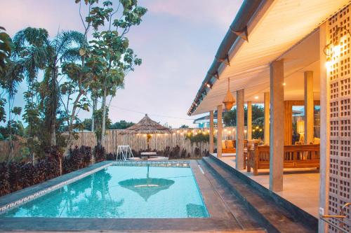 an external view of a house with a swimming pool at Villa Andante By The Villas 100 in Bogor