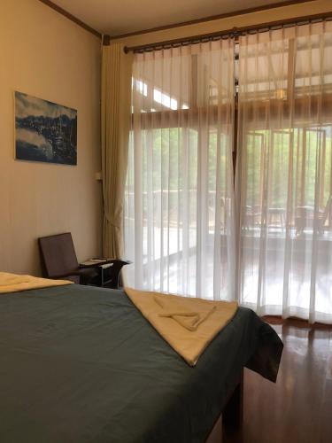 a bedroom with a bed and a large window at Baan Chan Lay Koh Chang in Ko Chang