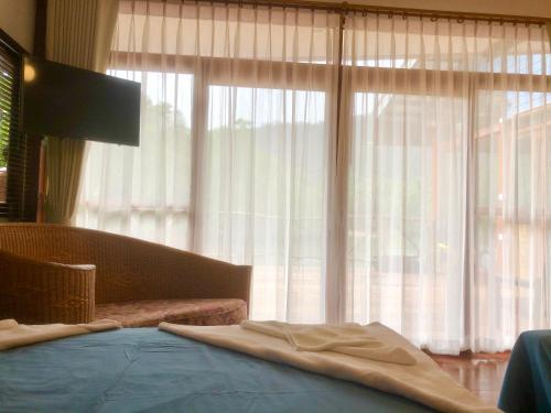 a bedroom with a bed and a large window at Baan Chan Lay Koh Chang in Ko Chang