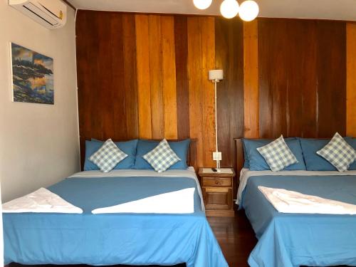 two beds in a room with blue sheets at Baan Chan Lay Koh Chang in Ko Chang