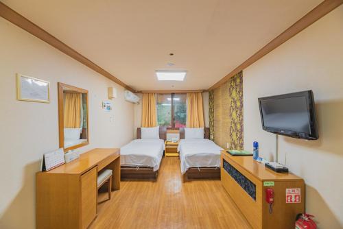 a hospital room with two beds and a flat screen tv at Osaek Greenyard Hotel in Yangyang