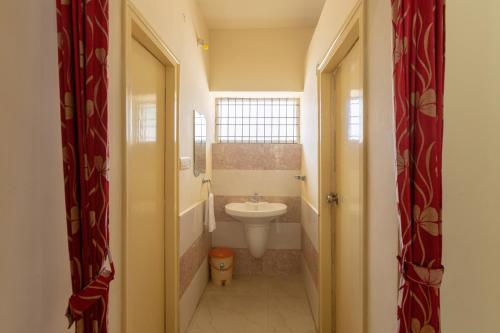Un baño pequeño con lavabo e inodoro. en KSTDC Hotel Mayura Shantala Halebeedu, en Halebīd