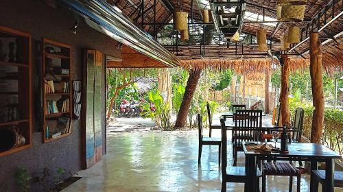 una sala da pranzo con tavoli e sedie in un ristorante di Herbs Guest House and Restaurant near the Sea a Moalboal