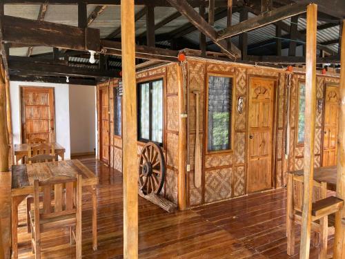 a room with wooden walls and wooden tables and chairs at Rio Beach Resort in Alegria