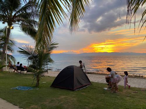 a group of people standing around a tent on the beach at Rio Beach Resort in Alegria