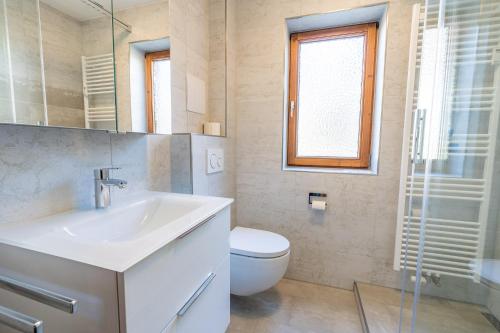 uma casa de banho com um lavatório, um WC e uma janela. em Bergsonne em Bad Hindelang