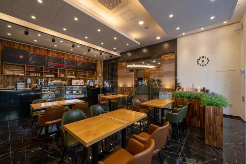 a restaurant with wooden tables and chairs at Ramada by Wyndham Seoul Dongdaemun in Seoul