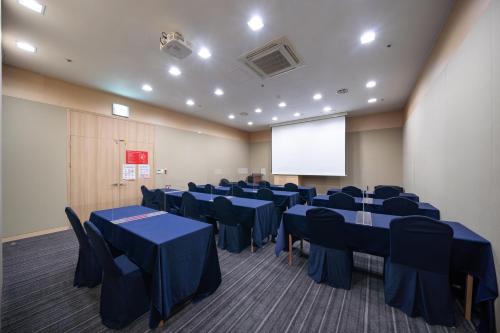 a conference room with blue tables and chairs and a screen at Ramada by Wyndham Seoul Dongdaemun in Seoul