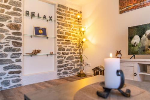 a candle on a table in a room with a stone wall at Chalet Ramona in Grächen